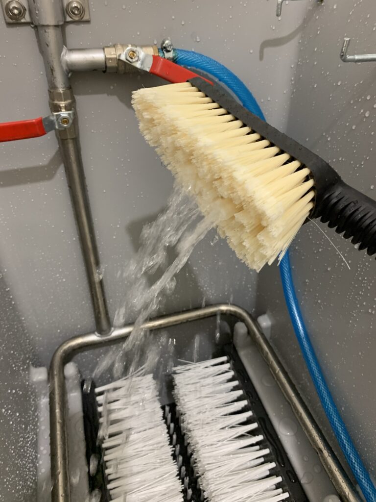 Water flowing through handbrush, making it easy to remove dirt and soil. 